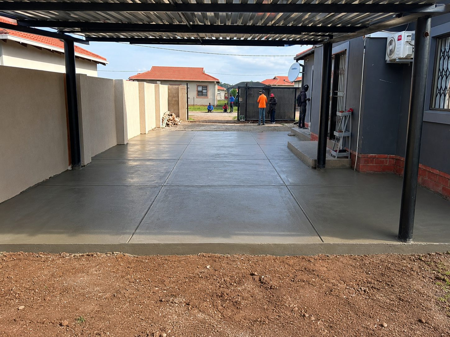 Residential carport and freshly laid concrete driveway